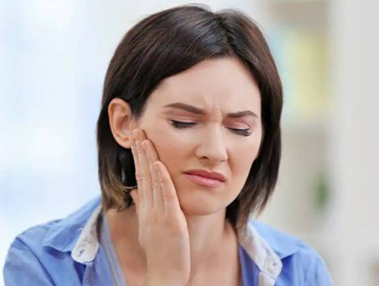 Woman holding jaw in pain