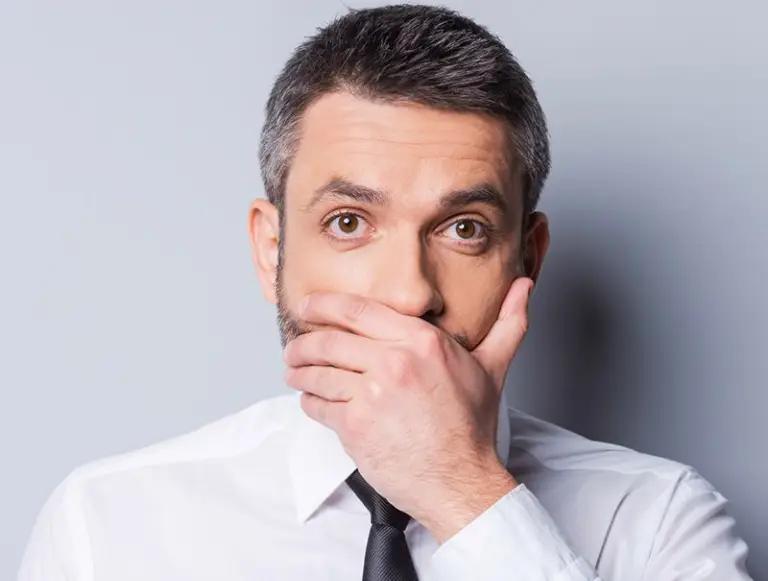 Man in business suit covering his mouth