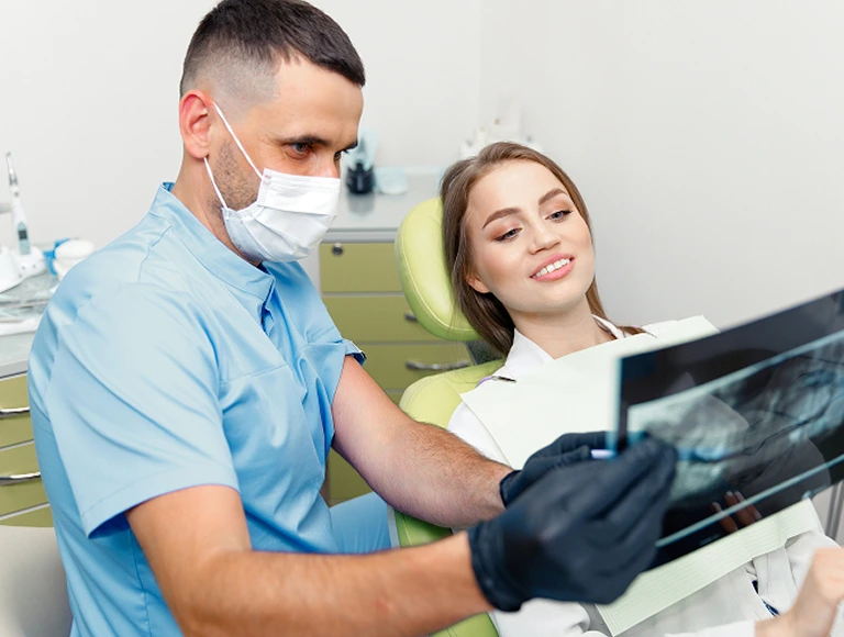 Dentist and patient looking at digital x-rays