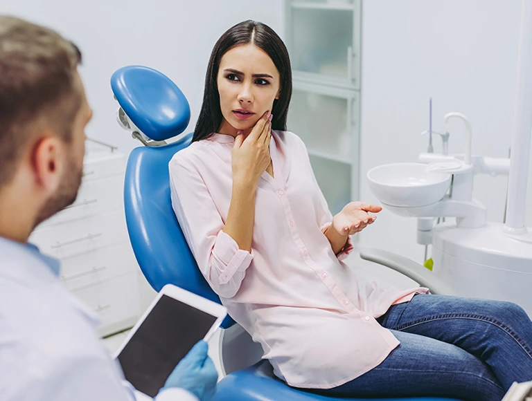 Woman holding cheek in pain