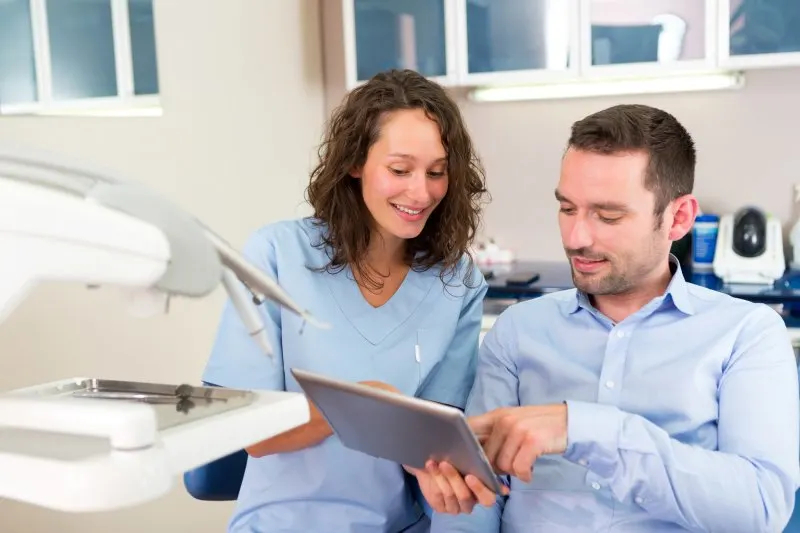 A male patient discussing with a female dentist