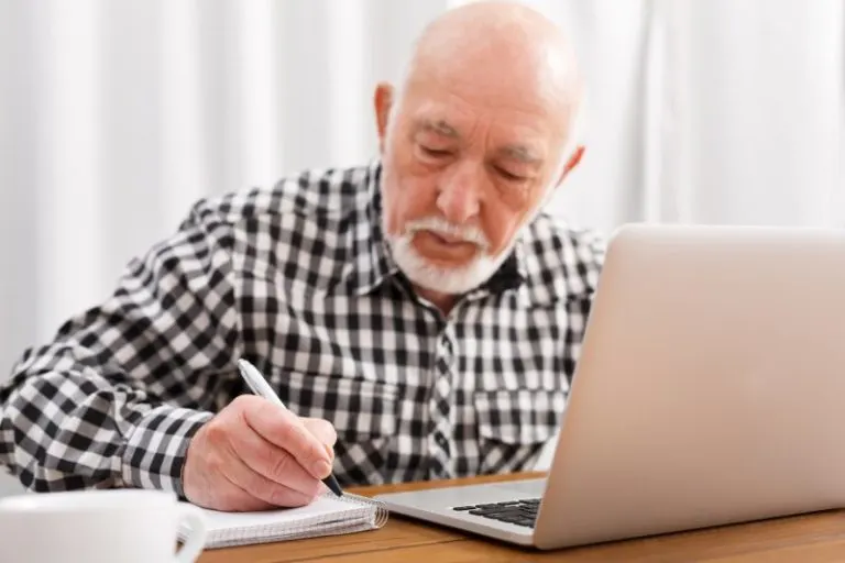 mature man writing on a notepad