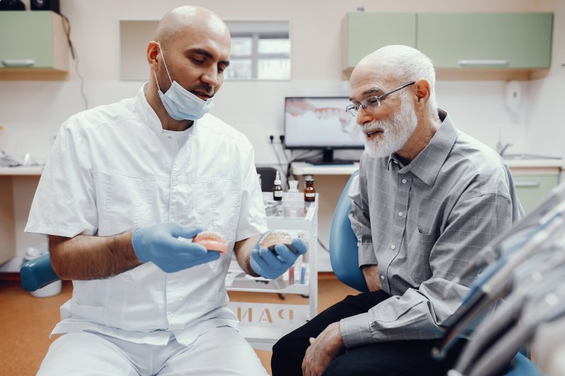An older man talking to his dentist about dentures